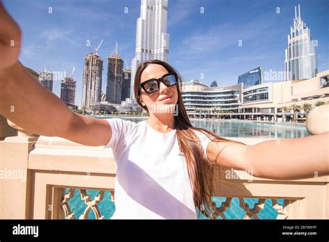Pretty Young Woman Tourist Takes Selfie Portrait At Dubai Fountain At