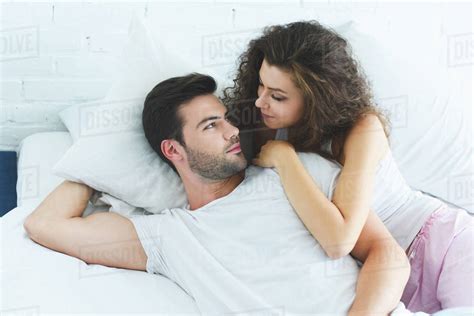 high angle view of beautiful young couple in love lying in bed and looking at each other - Stock ...