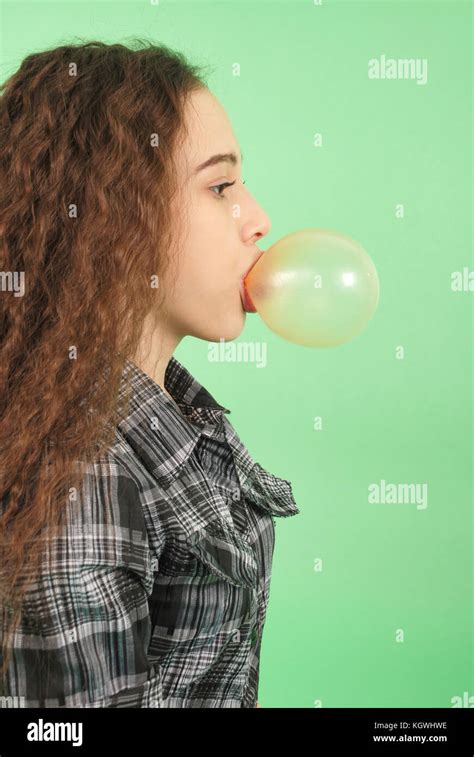 Girl Blowing A Bubblegum Bubble Isolated On Green Stock Photo Alamy