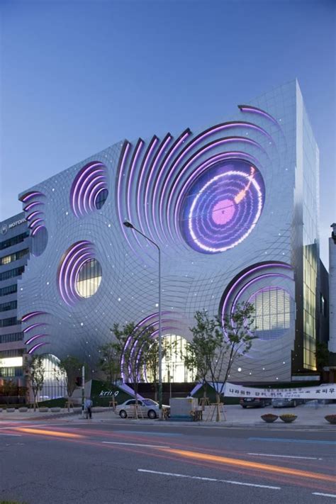 An Artistic Building Is Lit Up With Purple Lights And Circles On The
