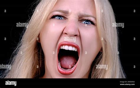 Angry Woman Yells In Rage As She Looking At Camera On Black Background