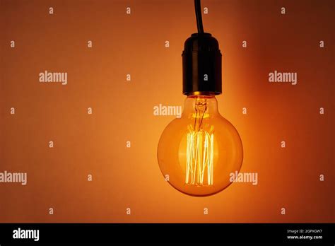 Vintage Light Bulb On Orange Background With Copy Space Glowing Edison