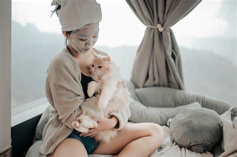 An Asian Chinese Teenager Girl Doing Face Spa Mask With Her Cat In