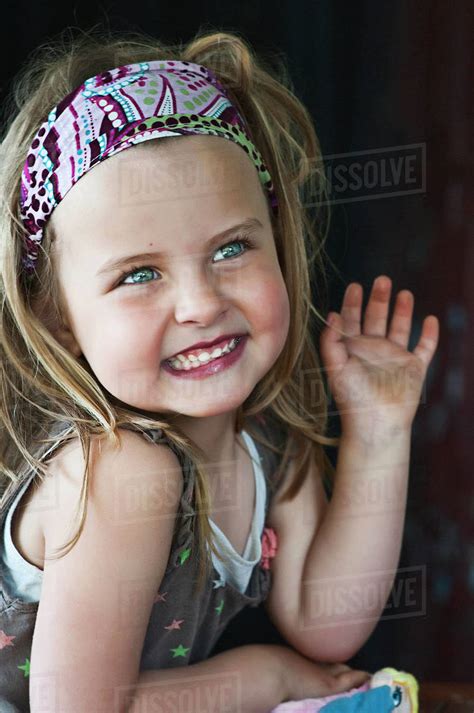 Portrait Of A Smiling Girl Waving Stock Photo Dissolve