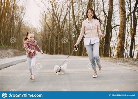 Madre Con Hija En Un Bosque De Primavera Con Perro Imagen De Archivo
