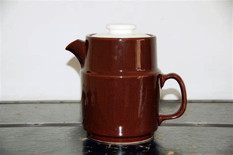 A Brown Coffee Pot Sitting On Top Of A Counter
