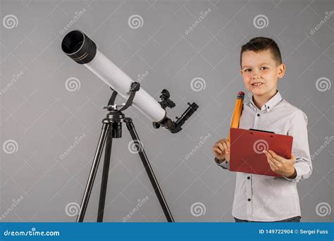 Young Astronomer Looks Through A Telescope And Writes In The Tablet