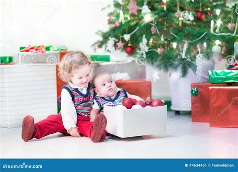 Little Toddler Girl And Her Newborn Brother Decorating Christmas Tree
