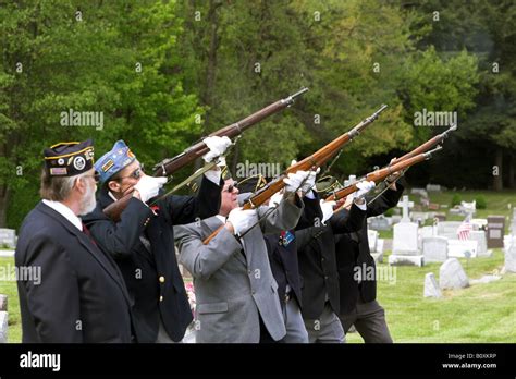 The Honor Guard Performs A Gun Salute At The Funeral Of A Veteran Of