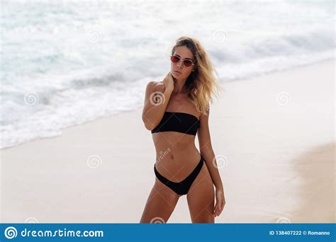 Sensual Girl In Black Swimwear And Sunglasses Resting On Beach Near