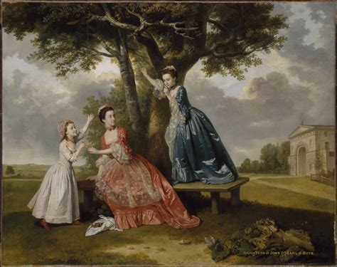 Two Women In Dresses Are Sitting On A Bench Under A Tree And Another