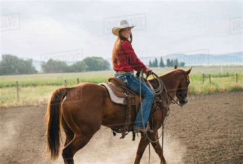 Caucasian Cowgirl Riding Horse On Ranch Stock Photo Dissolve