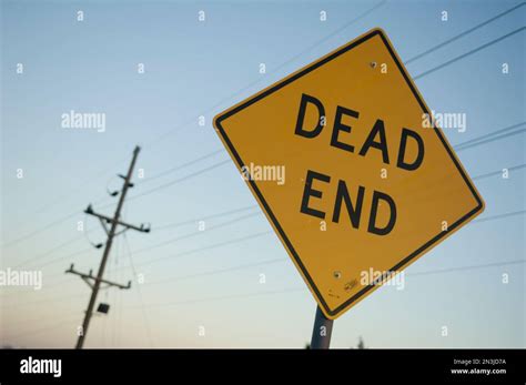 Dead End Yellow Caution Road Sign With Overhead Power Lines In The