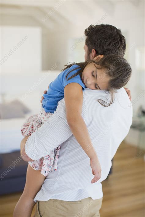father carrying sleeping daughter stock image f014 2983 science photo library