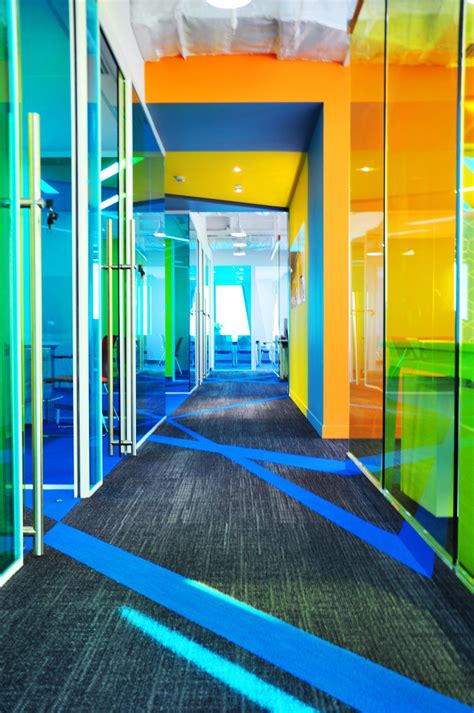 An Office Hallway With Brightly Colored Walls And Carpet