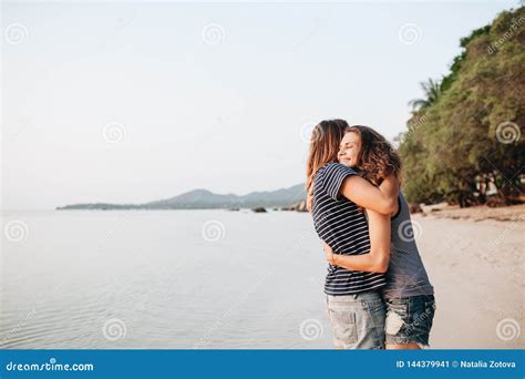 Two Smiling Friends Hugging Each Other On The Beach Stock Image Image