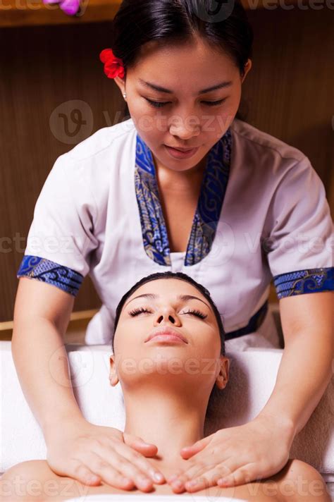 Spa Serenity Confident Thai Massage Therapist Massaging Beautiful Young Woman Lying On Massage