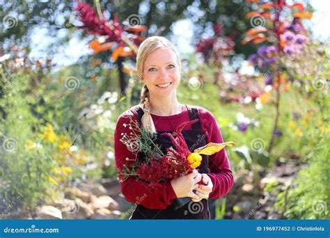 Beautiful Smiling Woman Gardener In Her Cottage Flower Garden Stock
