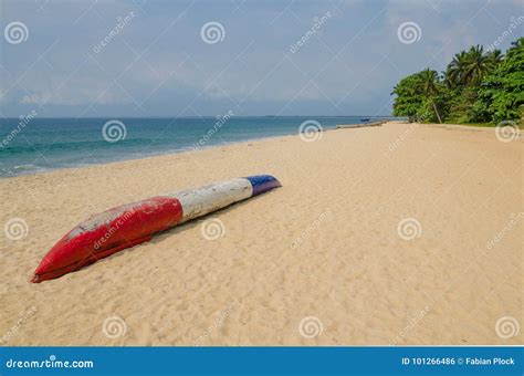 Colorful Dugout Fishing Boat Laying On Deserted Tropical Beach At
