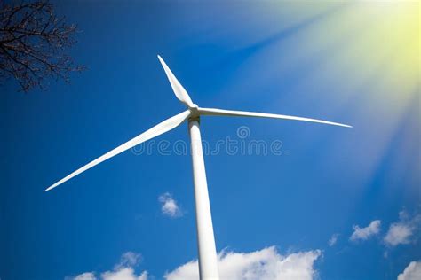 Wind And Solar Power Turbine In Sunshine Against Blue Sky Stock Photo