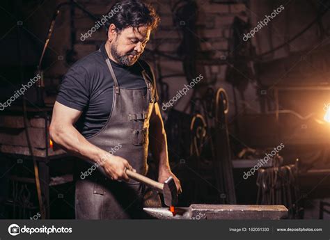 Blacksmith Manually Forging The Molten Metal On The Anvil In Smithy