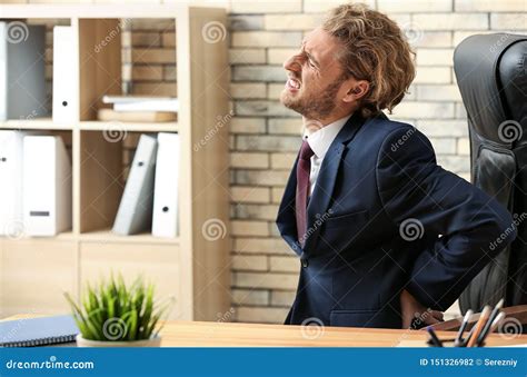 Young Businessman Suffering From Back Pain In Office Stock Photo