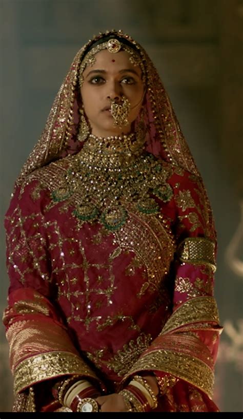 A Woman In A Red And Gold Outfit With Her Hands On Her Hips Looking At