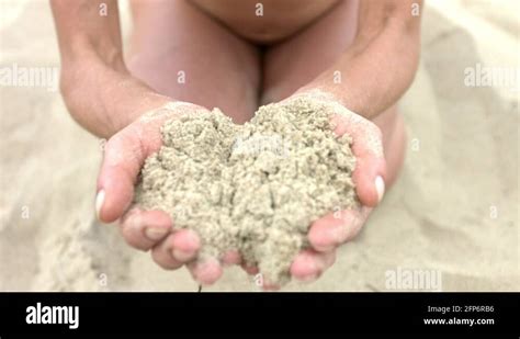 close up of a woman which is kneeling at the sandy beach and runs sand stock video footage alamy