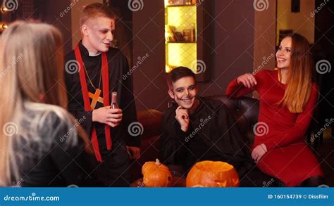 Young People In Costumes Are Celebrating Halloween Holiday Pumpkin On