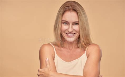 feeling attractive portrait of beautiful and happy mature woman smiling at camera while posing