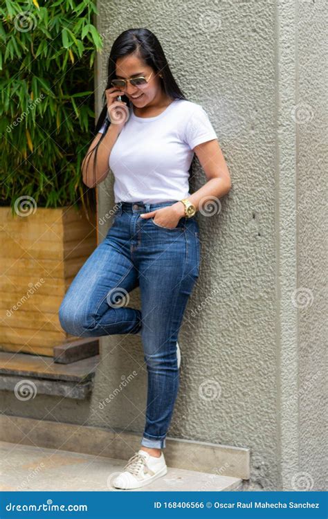 Beautiful Colombian Woman Lying On A City Wall Talking On Cellphone