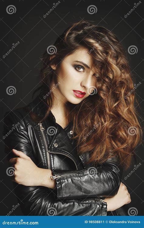 Beautiful Young Woman Posing In Black Leather Jacket Over Grey B Stock