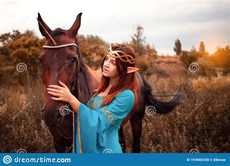 Beautiful Young Female Elf With Long Dark Wavy Hair Petting Her Horse