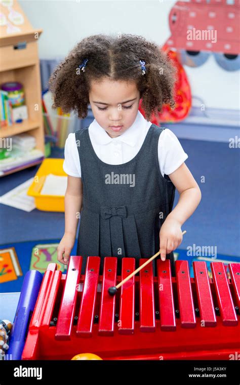 Little Girl Playing On A Xylophone In A Nursery Classroom Stock Photo