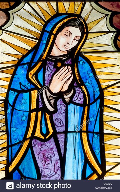 A Depiction Of The Virgin Mary In A Stained Glass Window At A Catholic