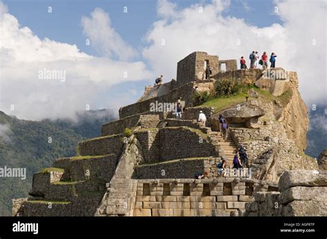 Peru Machu Picchu Tourists Climb The Intiwatana Pyramid Stock Photo