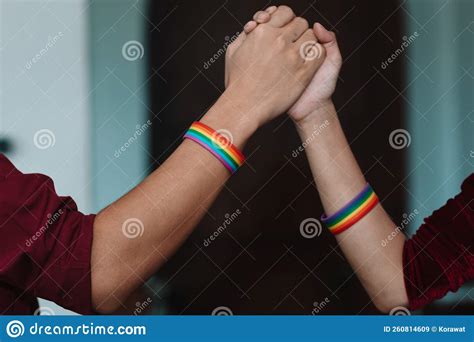 The Lgbt Couple Or Lgbtqia Couple Wear Rainbow Colored Wristbands On Their Wrists And Hold