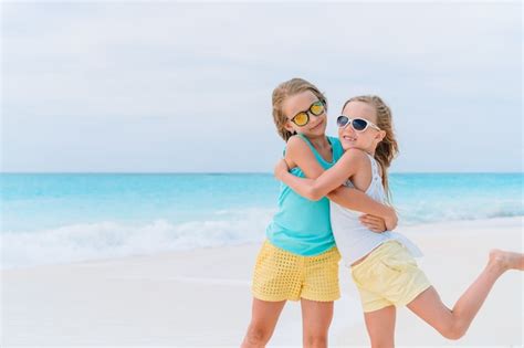 Niñas divirtiéndose en la playa tropical durante las vacaciones de verano jugando juntos Foto