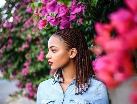 Additional cornrows are braided going forward on each side of the head and hanging. TREND: CORNROWS WITH BEADS