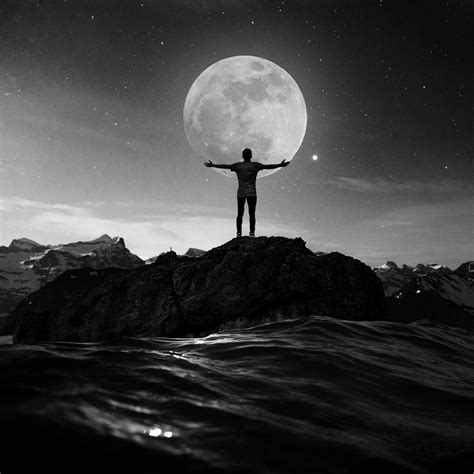 A Man Standing On Top Of A Rock With His Arms Outstretched In Front Of