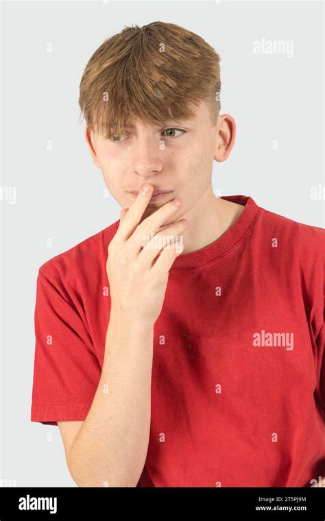 A Studio Portrait Of A Nervous Fifteen Year Old Teenage Boy Stock Photo
