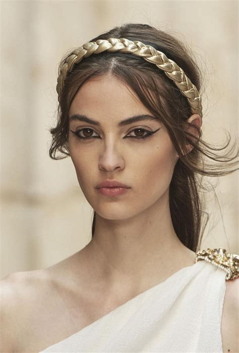 A Woman With Long Hair Wearing A White Dress And Gold Headband On Top