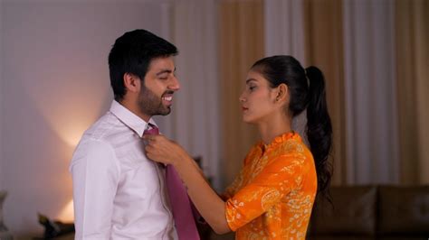 an indian wife helps her husband settle his tie before going t indian stock footage knot9