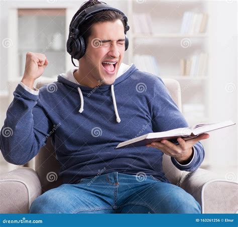 Young Man Reading Book And Listening To Audio Book Stock Photo Image