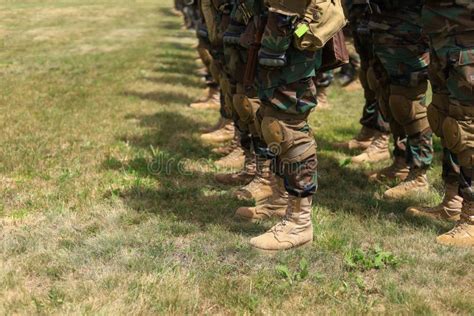 Legs Of Real Soldiers In Military Boots And Clothes Standing In Formation On The Grass