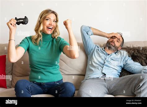 Happy Couple Plays At The Console With Joysticks Blonde Woman Wins The Game And Rejoices Sad