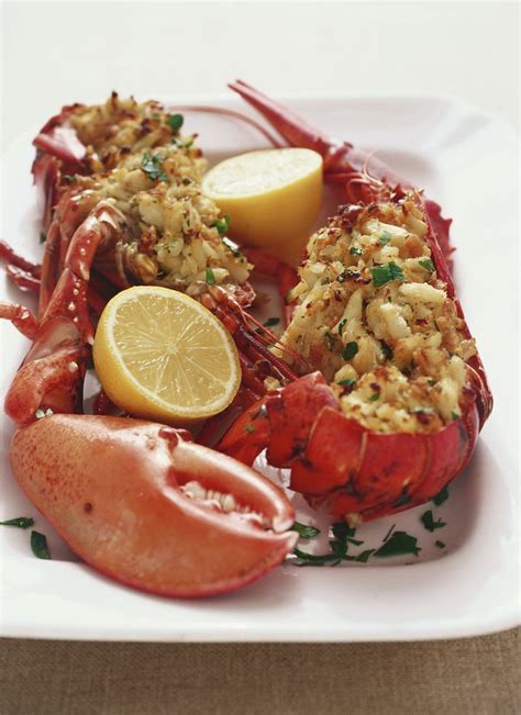 baked stuffed lobster with crab meat and bread crumb stuffing garnished with lemon halves