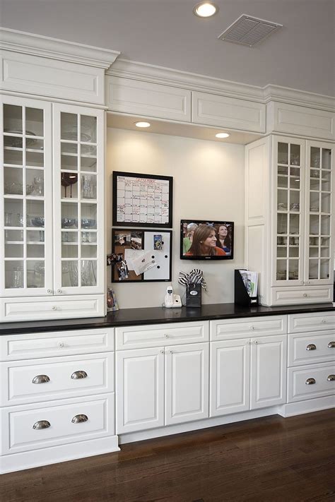 A Kitchen With White Cabinets And Black Counter Tops In The Center Is