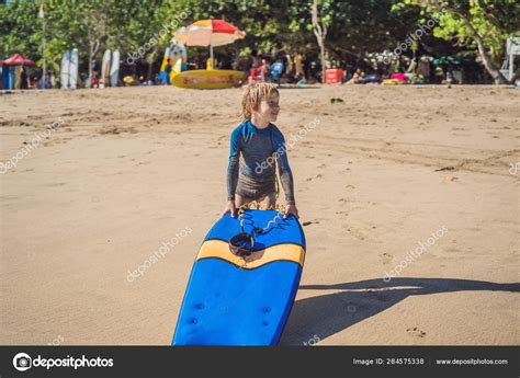 Happy Young Boy Having Fun At The Beach On Vacation With Boogie Board