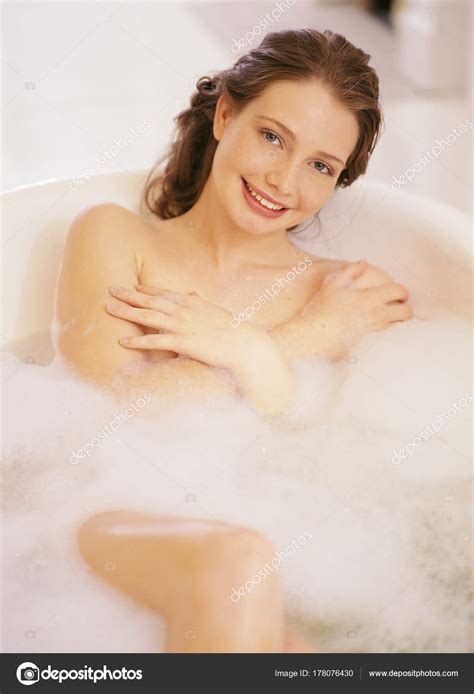 Sonriendo mujer desnuda acostada en el baño fotografía de stock